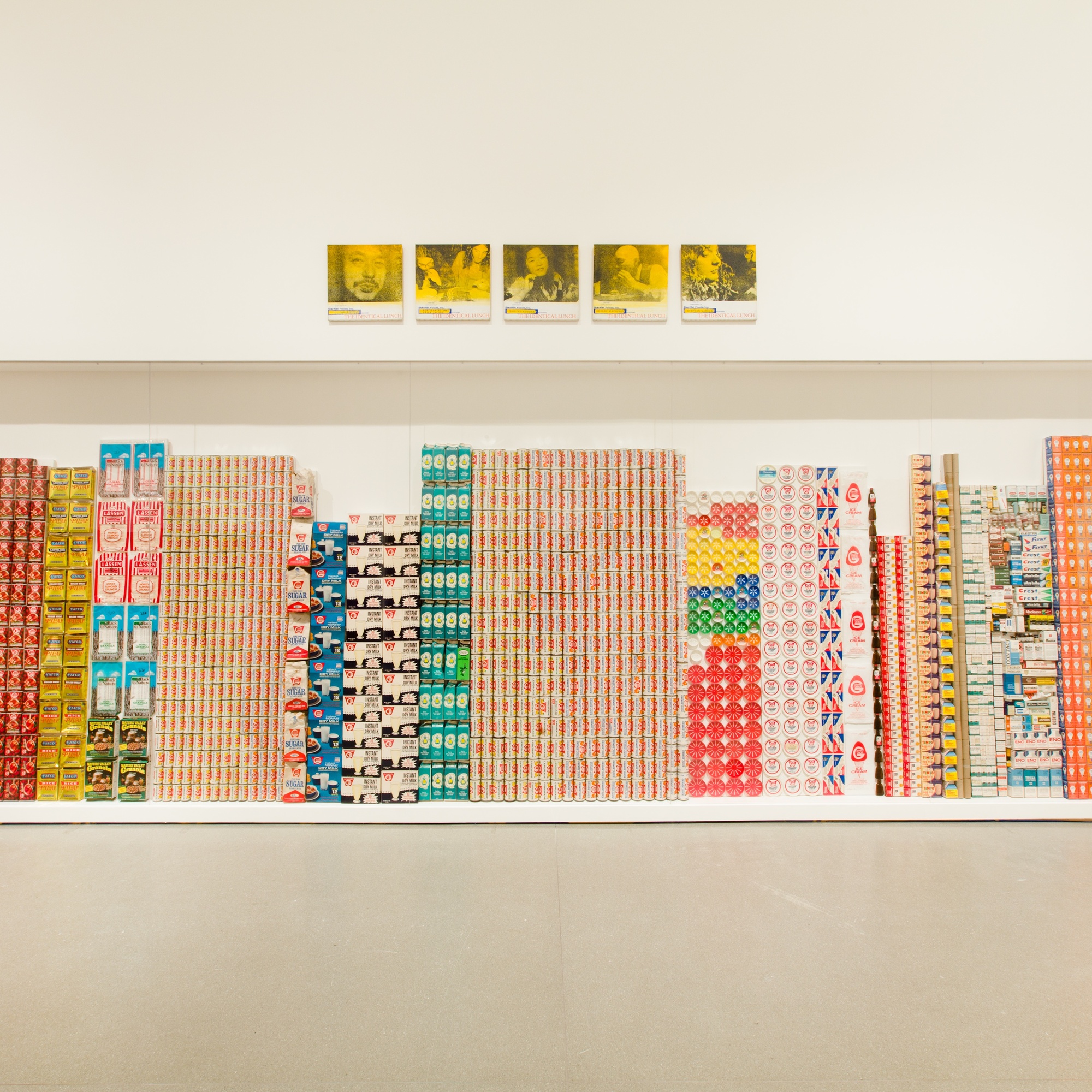 George Maciunas. One Year. 1973–74. Various empty containers and packaging. Above: Alison Knowles. Selections from The Identical Lunch. 1969. Screenprints on canvas. Installation view of both works at MoMA. The Museum of Modern Art, New York. The Gilbert and Lila Silverman Fluxus Collection. Photo: Jason Mandella