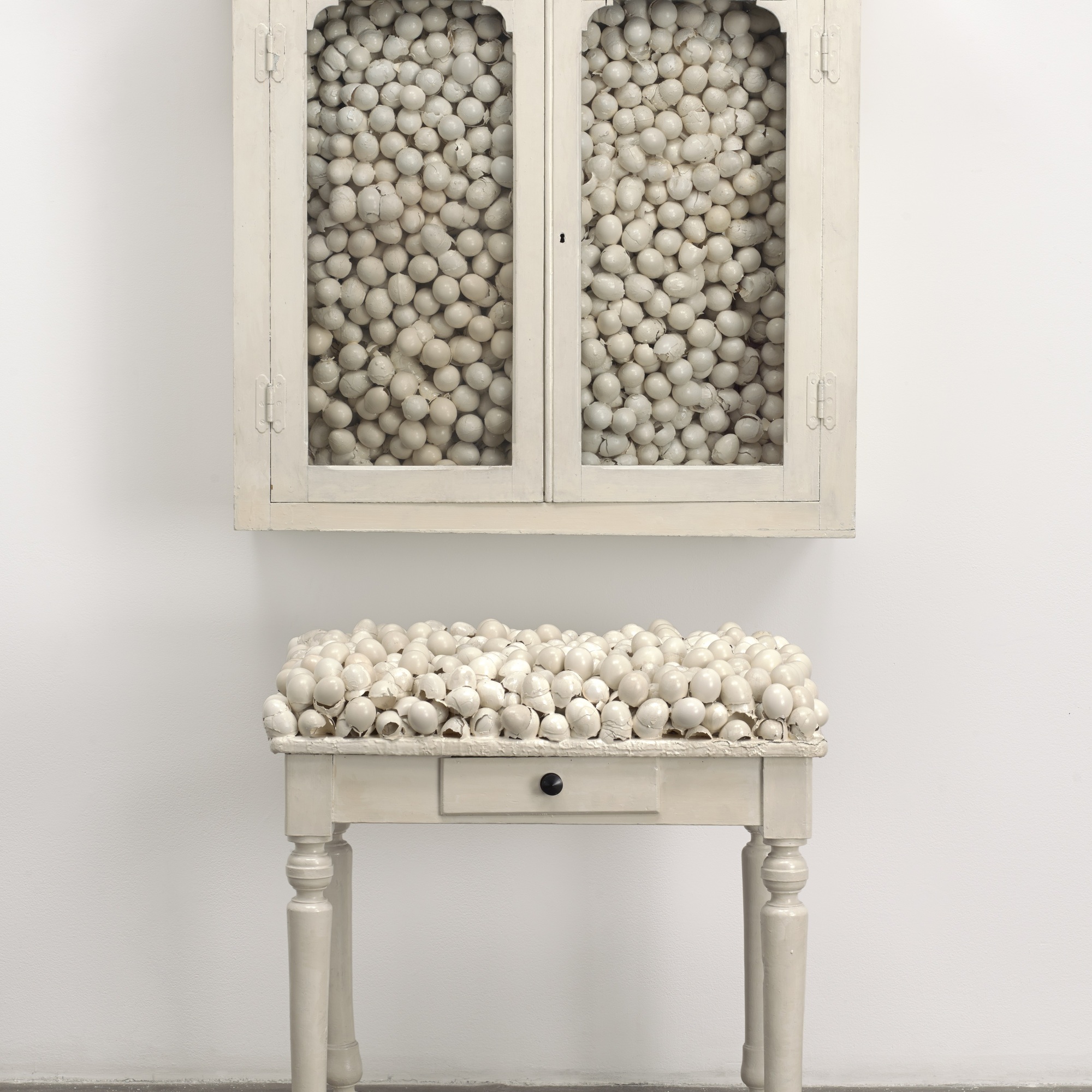 Marcel Broodthaers. Armoire blanche et table blanche (White Cabinet and White Table). 1965. Painted cabinet, table, and eggshells; cabinet 33 7/8 x 32 1/4 x 24 1/2″ (86 x 82 x 62 cm), table 41 x 39 3/8 x 15 3/4″ (104 x 100 x 40 cm). The Museum of Modern Art, New York. Fractional and promised gift of Jo Carole and Ronald S. Lauder. © 2015 Estate of Marcel Broodthaers/Artists Rights Society (ARS), New York/SABAM, Brussels