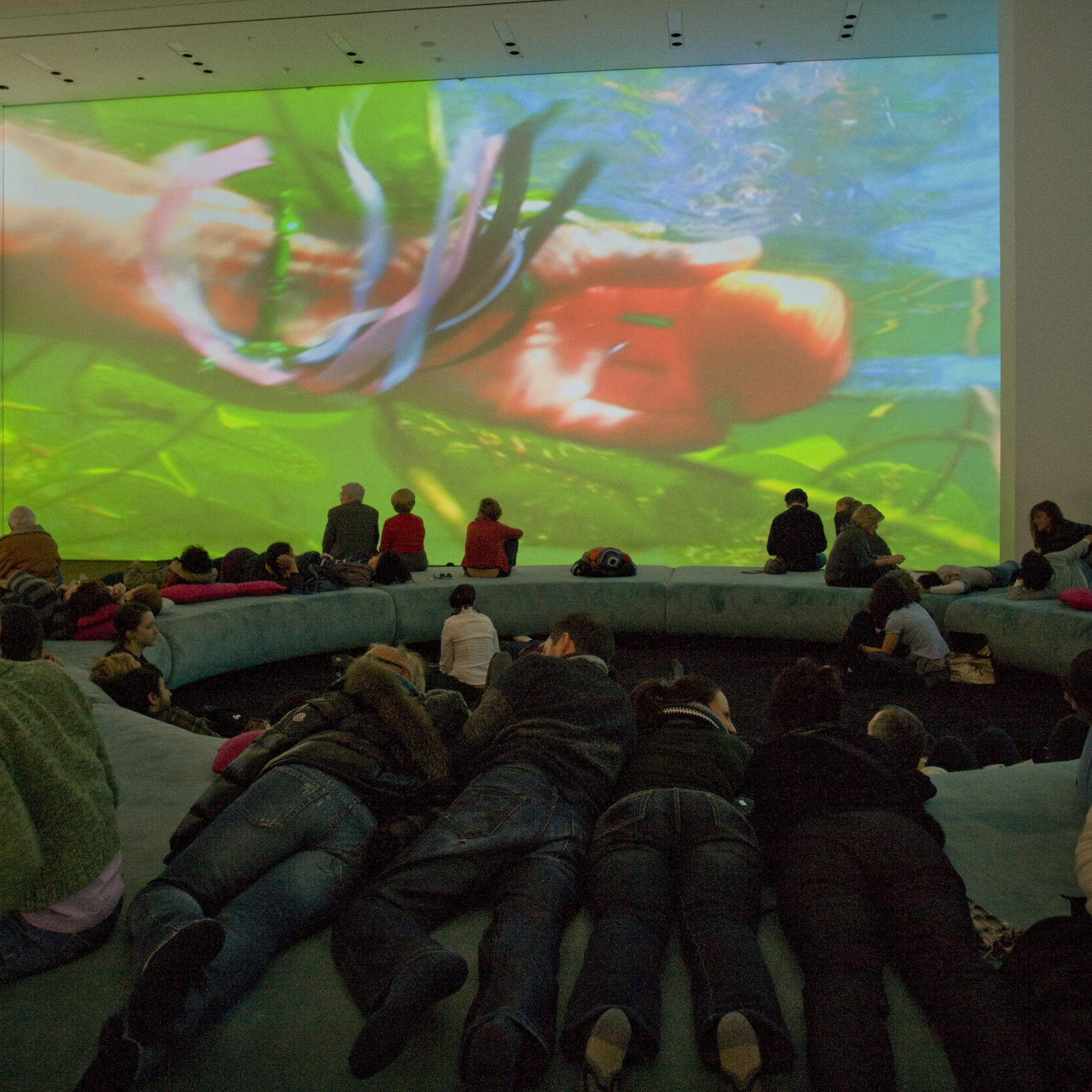 Pipilotti Rist. Pour Your Body Out (7354 Cubic Meters). 2008. Multichannel video projection (color, sound), projector enclosures, circular seating element, carpet. Installation view at The Museum of Modern Art, 2008. Photo: Thomas Griesel