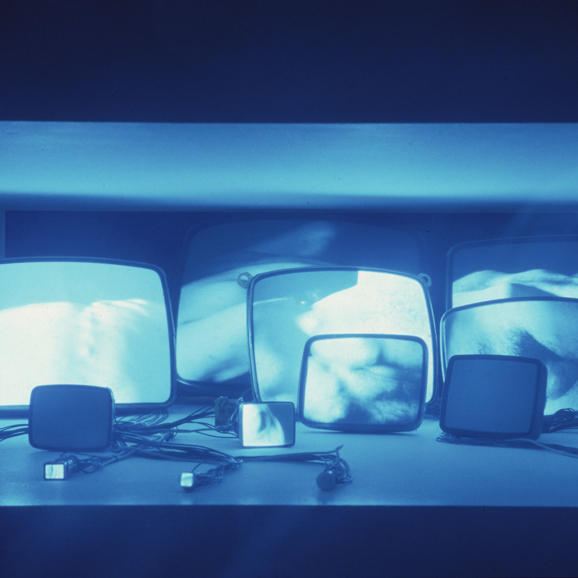 Gary Hill. Inasmuch As It Is Always Already Taking Place. 1990. Sixteen-channel video (black and white, sound), 16 black and white TV tubes and wires. Recessed in a wall 42″ (106.7 cm) from the floor, overall 16 × 53 3/4 × 68″ (40.6 × 136.5 × 172.7 cm). Gift of Agnes Gund, Marcia Riklis, Barbara Wise, Margot Ernst and purchase. © 1990 Gary Hill. Installation view of Video Spaces: Eight Installations at The Museum of Modern Art, New York