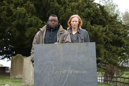 Isaac Julien and Tilda Swinton at Derek Jarman’s grave, Old Romney, Kent, 2008, during the making of Derek (2008). Photo: by Nina Kellgren. Courtesy Isaac Julien