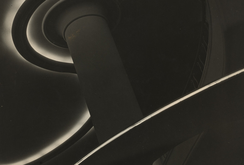 Image: Lucílio Corrêa Leite Filho. Fluorescent Symphony (Sinfonia fluorescente). c. 1960. Gelatin silver print. Acquired through the generosity of Estrellita Brodsky through the Latin American and Caribbean Fund Alt Text: A vertically-oriented black and white photograph with curvy white lines ebbing and flowing across the composition. Sections of architectural elements, like a column and curving walls, are obscured in shadow.