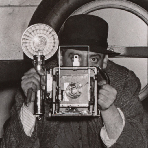 Weegee (Arthur Fellig). Self Portrait in Police Van. c. 1940. Gelatin silver print, 12 9/16 × 8 15/16&#34; (32 × 22.7 cm). Gift of the artist