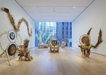 Installation view of the gallery &#34;Guadalupe Maravilla: Luz y Fuerza&#34; in the exhibition &#34;Collection 1970s–Present,” October 30, 2021 - October 30, 2022. The Museum of Modern Art, New York. Digital Image ©️ 2022 The Museum of Modern Art, New York. Photo: David Almeida Image description: A photograph of seven sculptures made out of natural materials by the artist Guadalupe Maravilla, installed on the floor and the walls of a MoMA gallery.