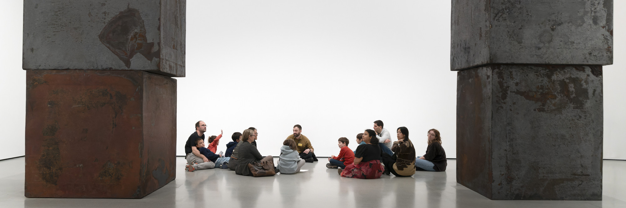 Photo: Martin SeckImage description: A group tour sits on the floor beside Richard Serra&#39;s sculpture Equal.