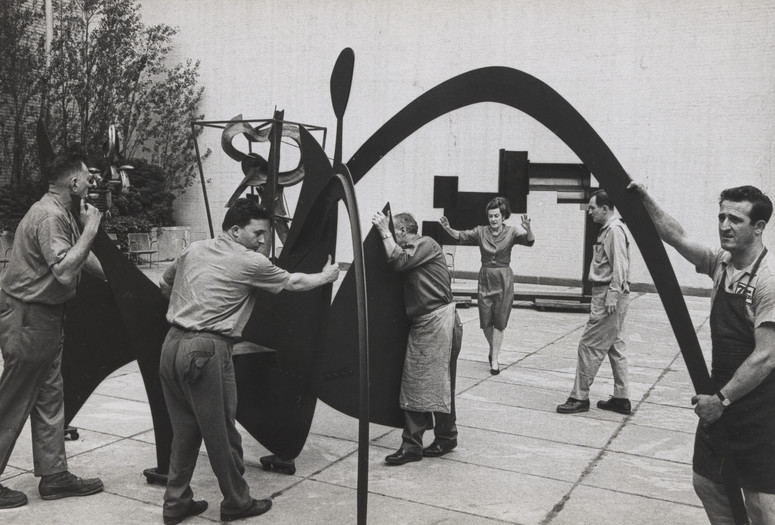 Curator Dorothy Miller installing Alexander Calder’s Black Widow (1959) in The Abby Aldrich Rockefeller Sculpture Garden, 1967. The Museum of Modern Art Archives, New York. Photograph by Dan Budnik. ©2023 The Estate of Dan Budnik.