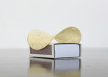 Thomas Schütte. Pringles. 2011. Pringles chip and matchbox. Collection of the artist, Düsseldorf. Photo: Luise Heuter. ©️ 2024 Thomas Schütte/Artists Rights Society (ARS), New York/VG Bild-Kunst, BonnImage description: A sculpture made of a Pringles brand swoop-shaped potato chip sitting on top of a rectangular matchbox
