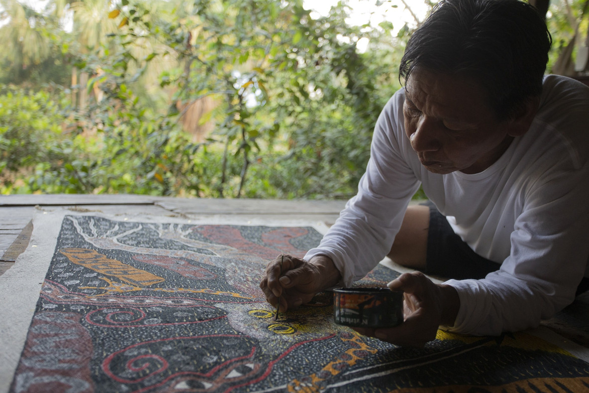 Santiago Yahuarcani trabajando en una pintura en Pebas, 2024