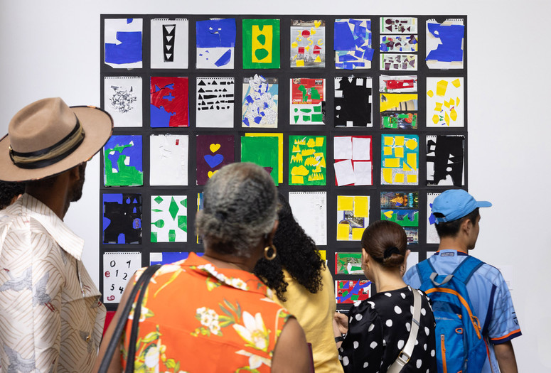 A group of visitors gather in front of a colorful artwork installation during an access exhibition opening at MoMA. Photo: onwhitewall.com. © 2025 The Museum of Modern Art, New York