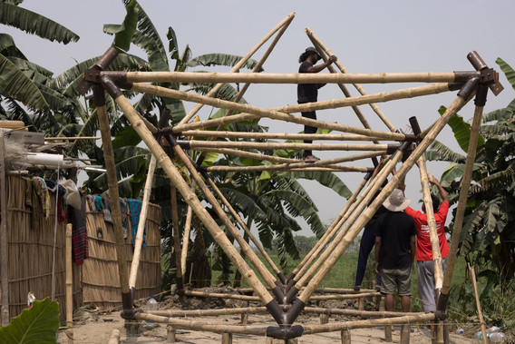 Photo of community assembling the bamboo frame of a Khudi Bari (tiny house) by Marina Tabassum Architects in Chandpur, Lower Meghna River, 2021