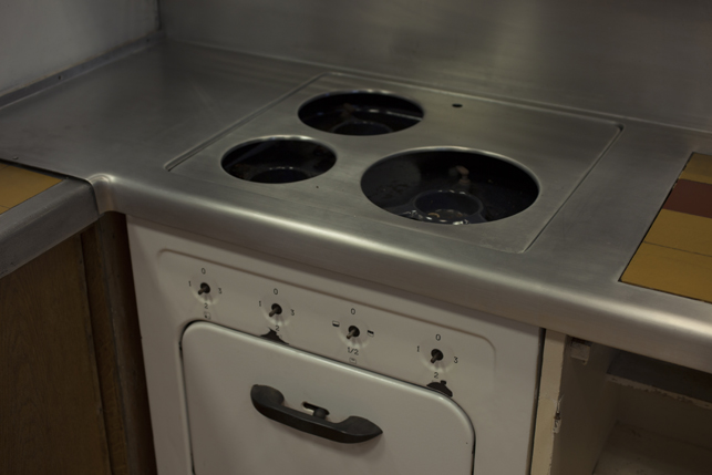 Detail of the kitchen stove, which is missing both the dials for the grills as well as the electric grills themselves.