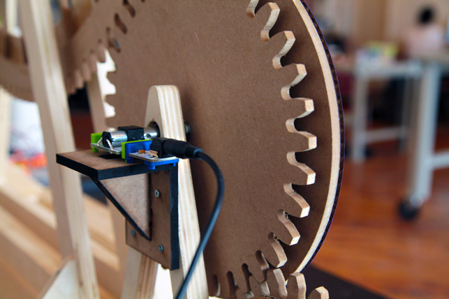 The Midown Design Store features a big wheel, which is propelled by a miniature cyclist, furiously pedaling ahead. His wheel is powered by a DC motor Bit, which is located behind the center wheel and pictured here. The motor controls a series of gears that create a spinning ferris wheel, aglow with LED lights.