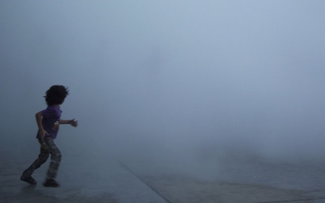 Children playing in Shiro Takatani’s installation composition, in Sharjah’s Heritage Area. 2013. Fog machine (water, nozzle, pump) and motorized mirror. Installation view, Sharjah Biennial 11, Re:emerge: Towards a New Cultural Cartography, March 13– May 13, 2013. Commissioned by Sharjah Art Foundation