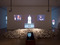 Installation view of Marina Abramović’s <i>Balkan Baroque,</i> The Museum of Modern Art, 2010. Photo by Jason Mandella. <i>Balkan Baroque</i> was originally performed in 1997 for four days, six hours each day at the 47th Venice Biennale. Three-channel video (color, sound), copper sinks and tub filled with black water, bucket, soap, metal brush, dress stained with blood. 24:47 min. © 2010 Marina Abramović. Courtesy the artist and Sean Kelly Gallery/Artists Rights Society (ARS), New York