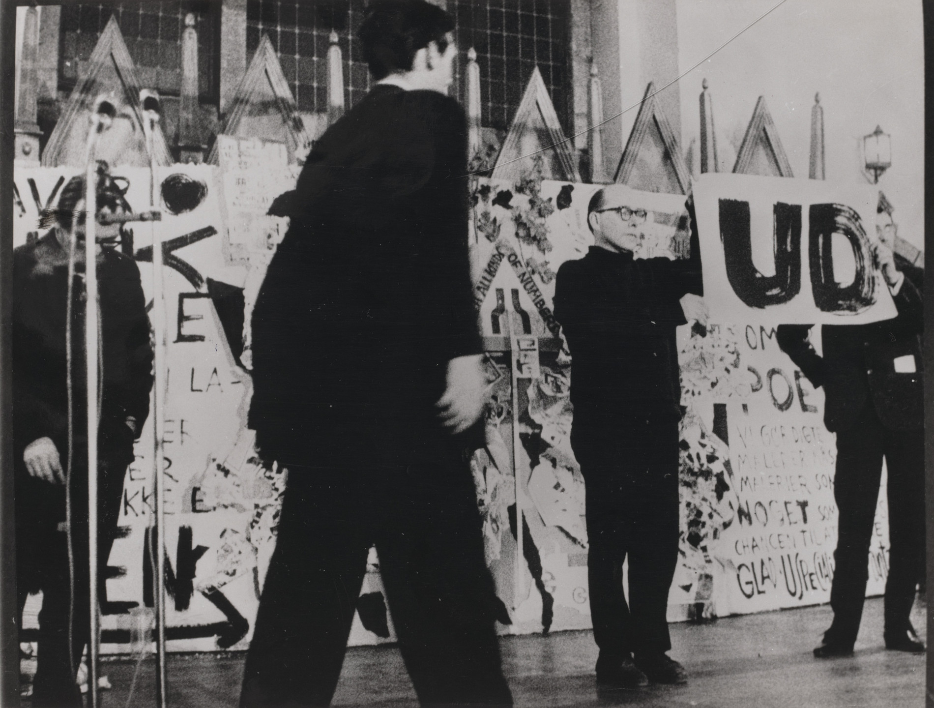 George Brecht, Emmett Williams, George Maciunas. George Brecht&#39;s Word Event (1961), performed by Emmett Williams and George Maciunas during Fluxus/Musik og Anti-Musik/det Instrumentale Teater, Nikolai Kirke, Copenhagen, November 23, 1962. 1962