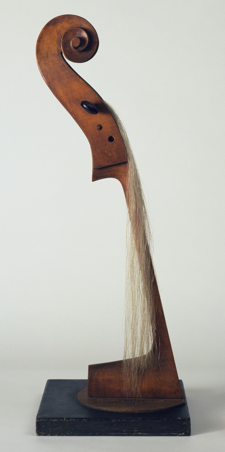 The image depicts a wooden sculpture resembling a violin scroll, mounted on a black base. Long, light-colored strands of hair cascade down from the middle section of the sculpture. This is an AI generated description. To give feedback, email ai@moma.org.