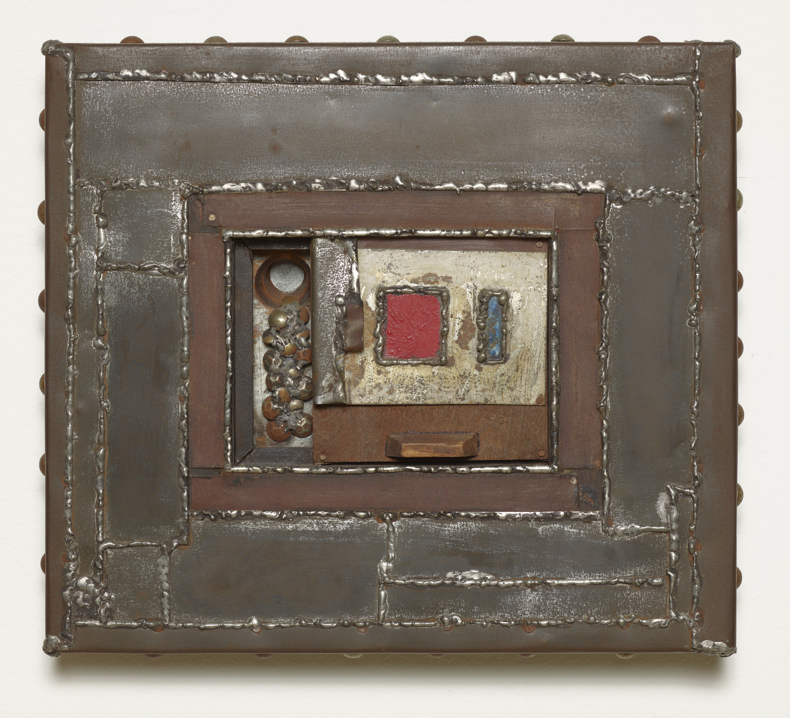 A mixed-media piece with metallic textures and a square design features shades of brown and silver, along with a striking red square. Various materials create a layered effect. This is an AI generated description. To give feedback, email ai@moma.org.