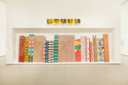 George Maciunas. One Year. 1973–74. Various empty containers and packaging. Above: Alison Knowles. Selections from The Identical Lunch. 1969. Screenprints on canvas. Installation view of both works at MoMA. The Museum of Modern Art, New York. The Gilbert and Lila Silverman Fluxus Collection. Photo: Jason Mandella