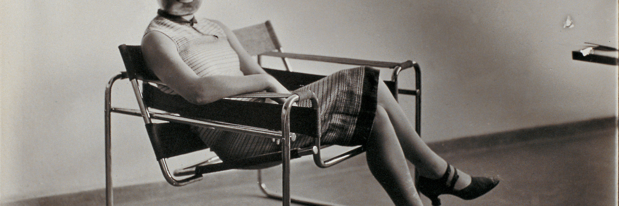 Erich Consemüller. Untitled (Woman [Lis Beyer or Ise Gropius] in B3 club chair by Marcel Breuer wearing a mask by Oskar Schlemmer and a dress in fabric designed by Beyer). c. 1926. Gelatin silver print. Private collection