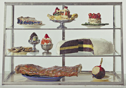 Claes Oldenburg. Pastry Case, I. 1961–62. Painted plaster sculptures on ceramic plates, metal platter, and cups in glass-and-metal case, 20 3/4 × 30 1/8 × 14 3/4″ (52.7 × 76.5 × 37.3 cm). The Museum of Modern Art, New York. The Sidney and Harriet Janis Collection. © 2012 Claes Oldenburg