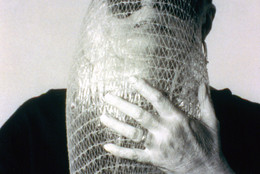 Lygia Clark wearing Máscara abismo com tapa-olhos (Abyssal mask with eye-patch, 1968), a work made of fabric, elastic bands, a nylon bag, and a stone, in use. Courtesy Associação Cultural “O Mundo de Lygia Clark,” Rio de Janeiro. Photo: Sergio Gerardo Zalis, 1986