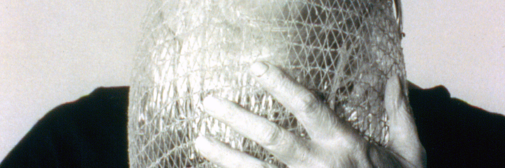 Lygia Clark wearing Máscara abismo com tapa-olhos (Abyssal mask with eye-patch, 1968), a work made of fabric, elastic bands, a nylon bag, and a stone, in use. Courtesy Associação Cultural “O Mundo de Lygia Clark,” Rio de Janeiro. Photo: Sergio Gerardo Zalis, 1986