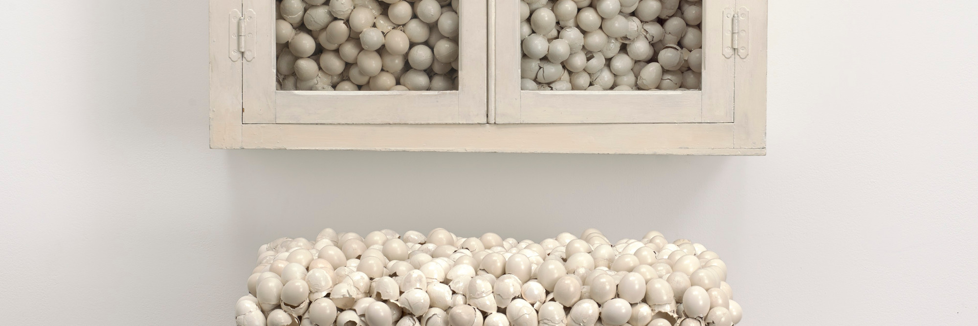 Marcel Broodthaers. Armoire blanche et table blanche (White Cabinet and White Table). 1965. Painted cabinet, table, and eggshells; cabinet 33 7/8 × 32 1/4 × 24 1/2″ (86 × 82 × 62 cm), table 41 × 39 3/8 × 15 3/4″ (104 × 100 × 40 cm). The Museum of Modern Art, New York. Fractional and promised gift of Jo Carole and Ronald S. Lauder. © 2015 Estate of Marcel Broodthaers/Artists Rights Society (ARS), New York/SABAM, Brussels