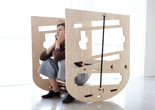 Caroline Woolard. Queer Rocker. 2013. CNC prototype, oak plywood, rachet straps, newspapers, 48 x 30 x 44”. Courtesy of the artist
