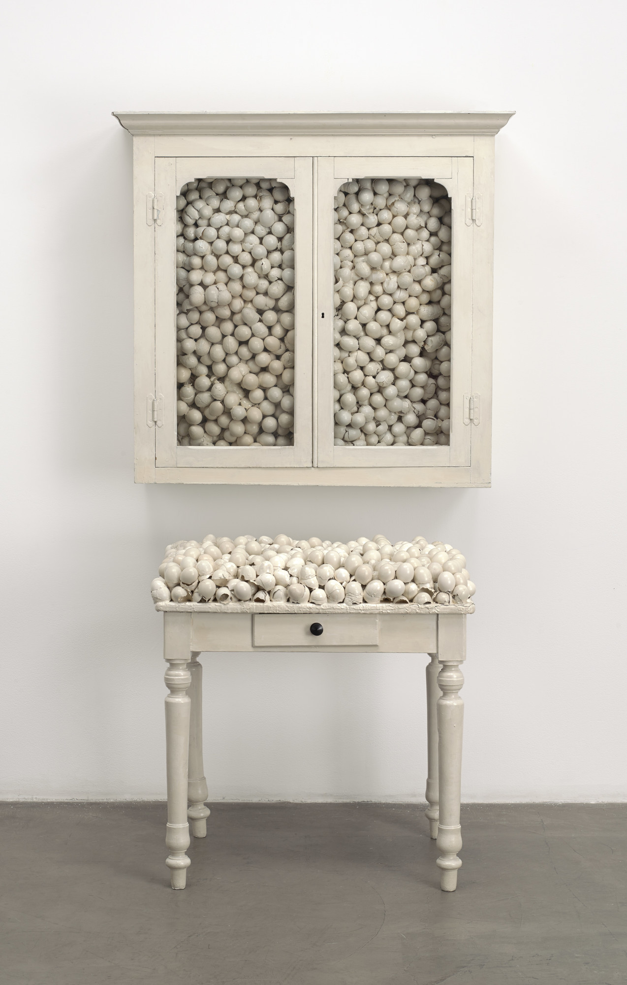Marcel Broodthaers (Belgian, 1924–1976). Armoire blanche et table blanche (White cabinet and white table). 1965. Painted furniture with eggshells, cabinet: 33 7/8 × 32 1/4 × 24 1/2 in. (86 × 82 × 62 cm); table: 41 × 39 3/8 × 15 3/4 in. (104 × 100 × 40 cm). The Museum of Modern Art, New York. Fractional and promised gift of Jo Carole and Ronald S. Lauder, 1992. © 2016 Estate of Marcel Broodthaers / Artists Rights Society (ARS), New York / SABAM, Brussels