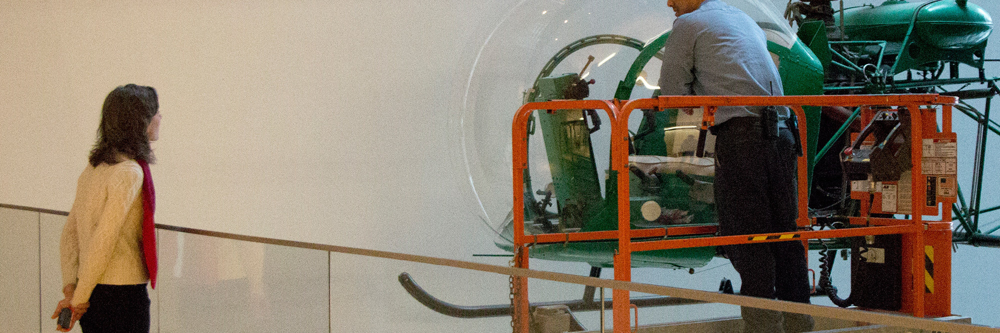 Artist Nina Katchadourian watches the dusting of the helicopter. Shown: Arthur Young. Bell-47D1 Helicopter. 1945. Manufacturer: Bell Helicopter Inc., Buffalo, NY. Aluminum, steel, and acrylic plastic, 9′ 2 3/4″ × 7′ 11″ × 42′ 8 3/4″ (281.3 × 302 × 1271.9 cm). Marshall Cogan Purchase Fund. Photo: Manuel Martagon. © 2016 The Museum of Modern Art