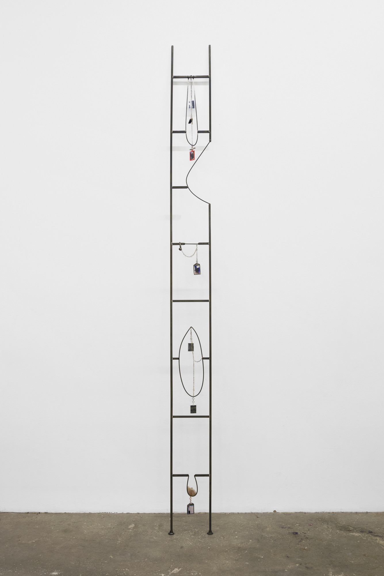 Em Rooney. _Pictures, Keychains, Freedom Ladder_. 2016. Welded steel, picture keychains, chromogenic color prints, pewter charms, chain, 119 x 9 inches (302.3 x 22.9 cm). Courtesy the artist and Bodega, New York. © 2018 Em Rooney
