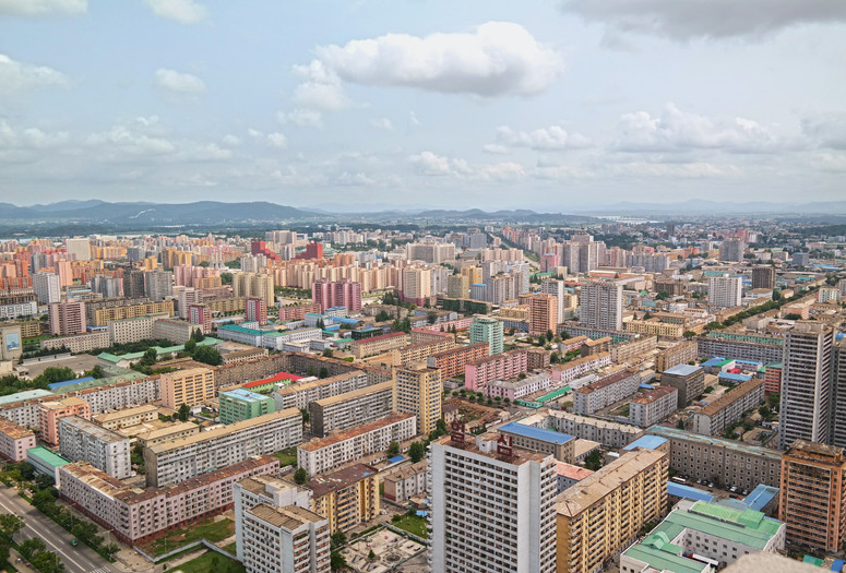 View from the top of the Tower of the Juche Idea in Pyongyang. The North Korean capital stretches out beneath you as a pastel-colored panorama, a rolling field of tower blocks painted in terracotta and yellow ochre, turquoise and baby blue—a distinctive color palette that recurs throughout the country’s architecture and interiors. © Oliver Wainwright