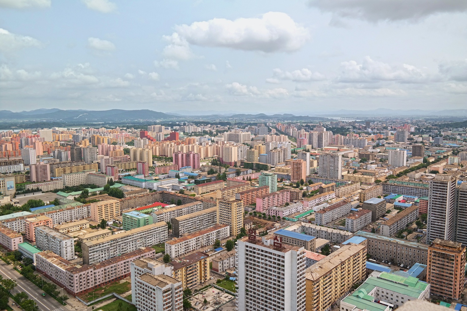 View from the top of the Tower of the Juche Idea in Pyongyang. The North Korean capital stretches out beneath you as a pastel-colored panorama, a rolling field of tower blocks painted in terracotta and yellow ochre, turquoise and baby blue—a distinctive color palette that recurs throughout the country’s architecture and interiors. © Oliver Wainwright
