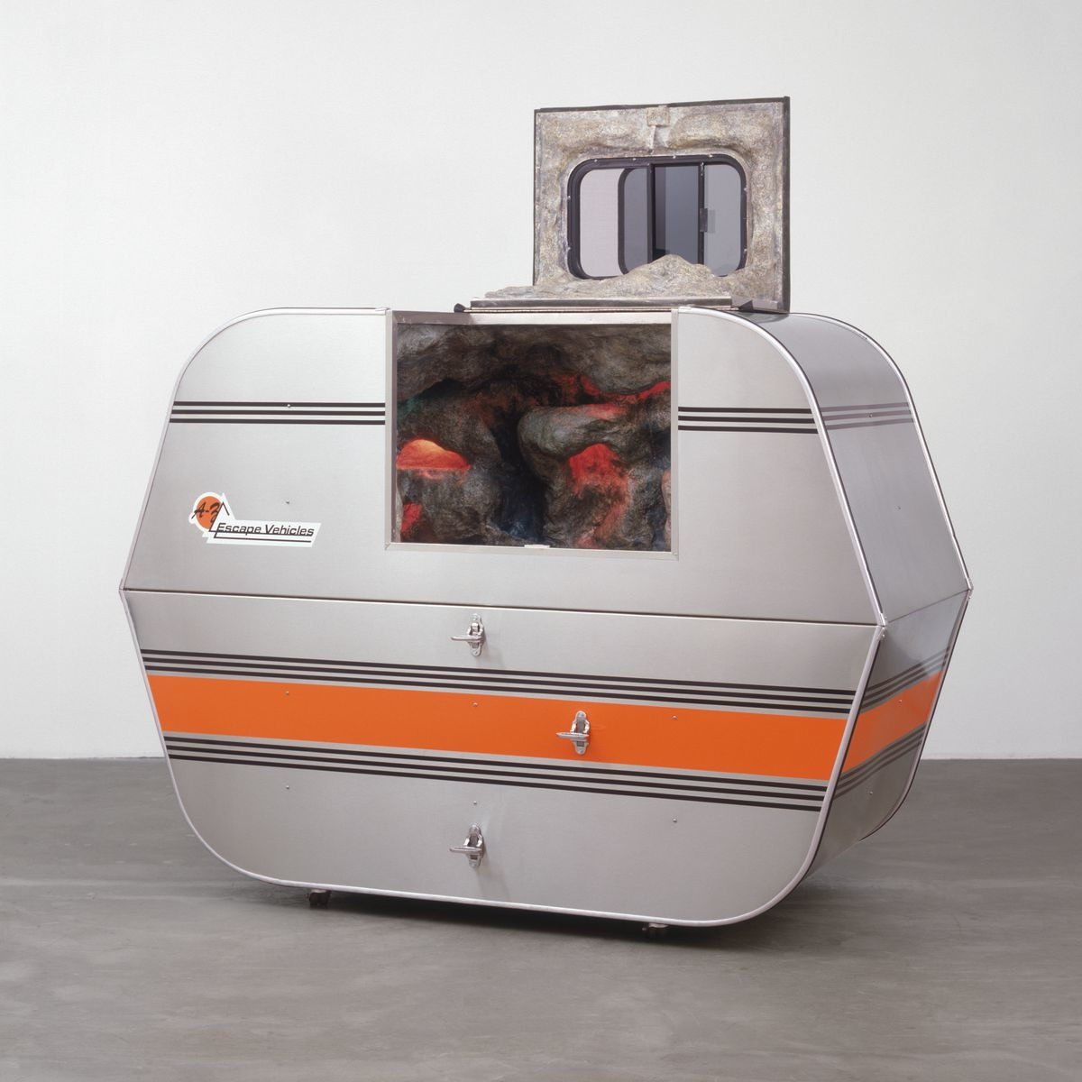 Andrea Zittel, A-Z Escape Vehicle: Customized by Andrea Zittel, 1996. Exterior: steel, insulation, wood and glass. Interior: colored lights, water, fiberglass, wood, papier-mâché, pebbles and paint, 62" x 7' x 40" (157.5 x 213.3 x 101.6 cm). The Norman and Rosita Winston Foundation, Inc. Fund and an anonymous fund. © 2012 Andrea Zittel. 