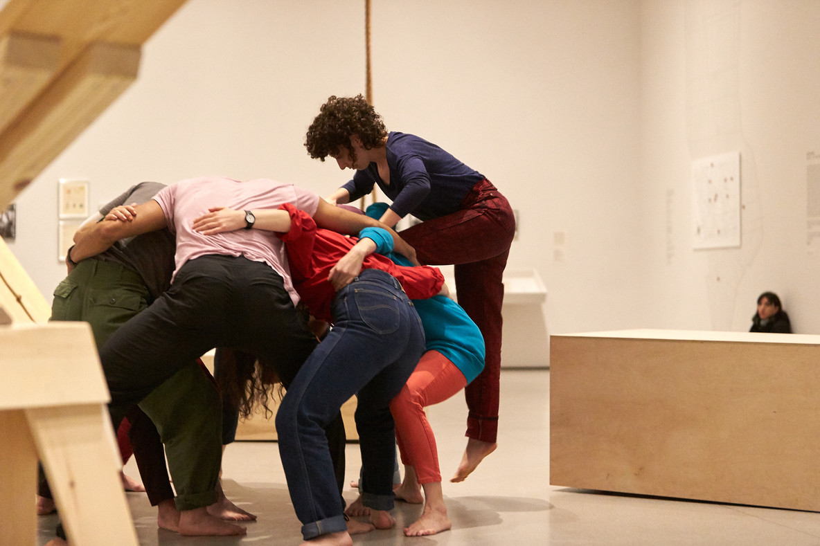 Huddle is a continually shifting mass of bodies. Seven to nine performers create a solid base and take turns climbing over the group. In doing this, they create a sculptural form Forti has often described as a mountain.