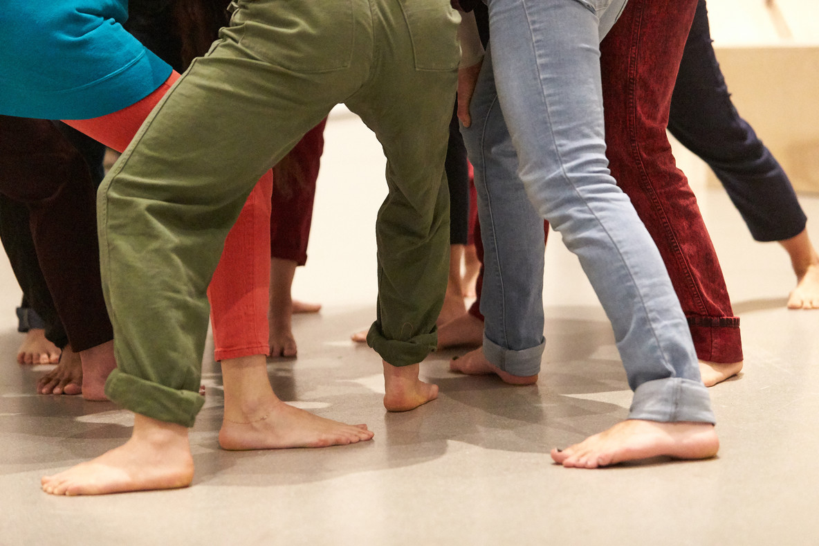 The performers negotiate to be part of a group as they rely on the weight and balance of their fellow performers for support.