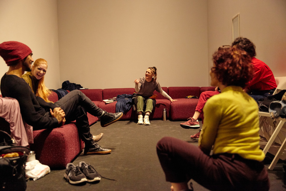 The cast assembles in the green room, a private space built into the floor plan of the exhibition where performers rest and warm up between performances. Assistant performance coordinator Sammy Roth is on hand to ensure they have everything they need.