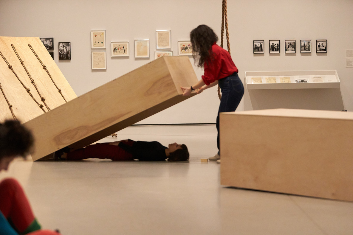 In Platforms, Vanessa Vargas and Christiana Cefalu lie on the floor beneath plywood boxes of different sizes. Forti has described this piece as akin to lovers asleep next to each other; they are both together yet in their own separate worlds. Vanessa and Christiana whistle with each other in an intimate duet.