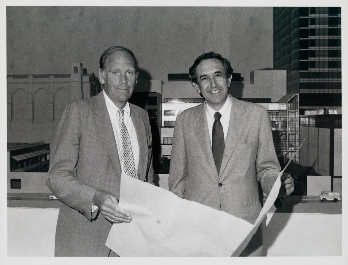 MoMA director Richard Oldenburg (left) and architect César Pelli with a model of the new building in the background, summer 1983
