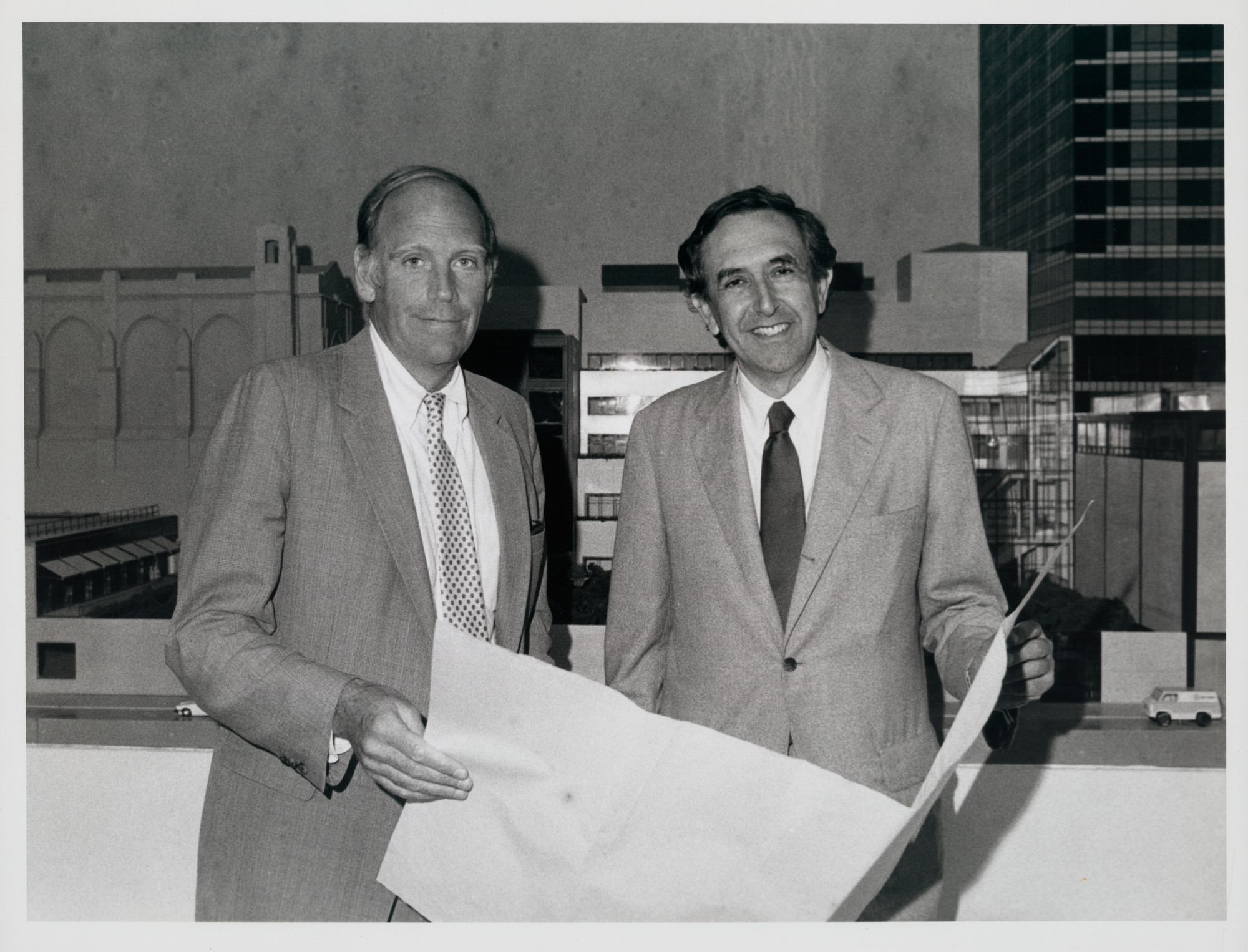MoMA director Richard Oldenburg (left) and architect César Pelli with a model of the new building in the background, summer 1983