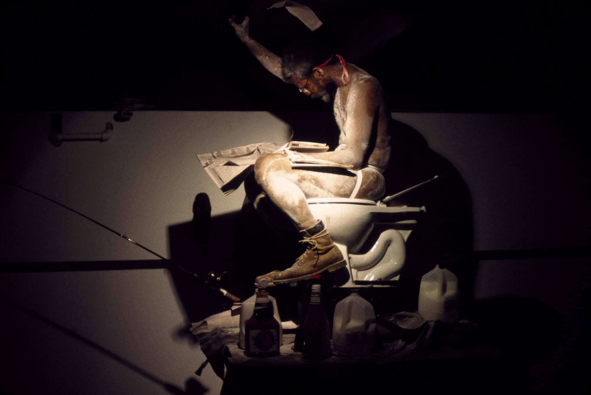 Pope.L (American, born 1955). _Eating the Wall Street Journal, Version 3, SculptureCenter, New York_. 2000. Inkjet print, 10 × 15" (25.4 × 38.1 cm). The Museum of Modern Art, New York. Acquired in part through the generosity of Jill and Peter Kraus, Anne and Joel S. Ehrenkranz, The Contemporary Arts Council of The Museum of Modern Art, The Jill and Peter Kraus Media and Performance Acquisition Fund, and Jill and Peter Kraus in honor of Michael Lynne. © Pope.L, courtesy the artist