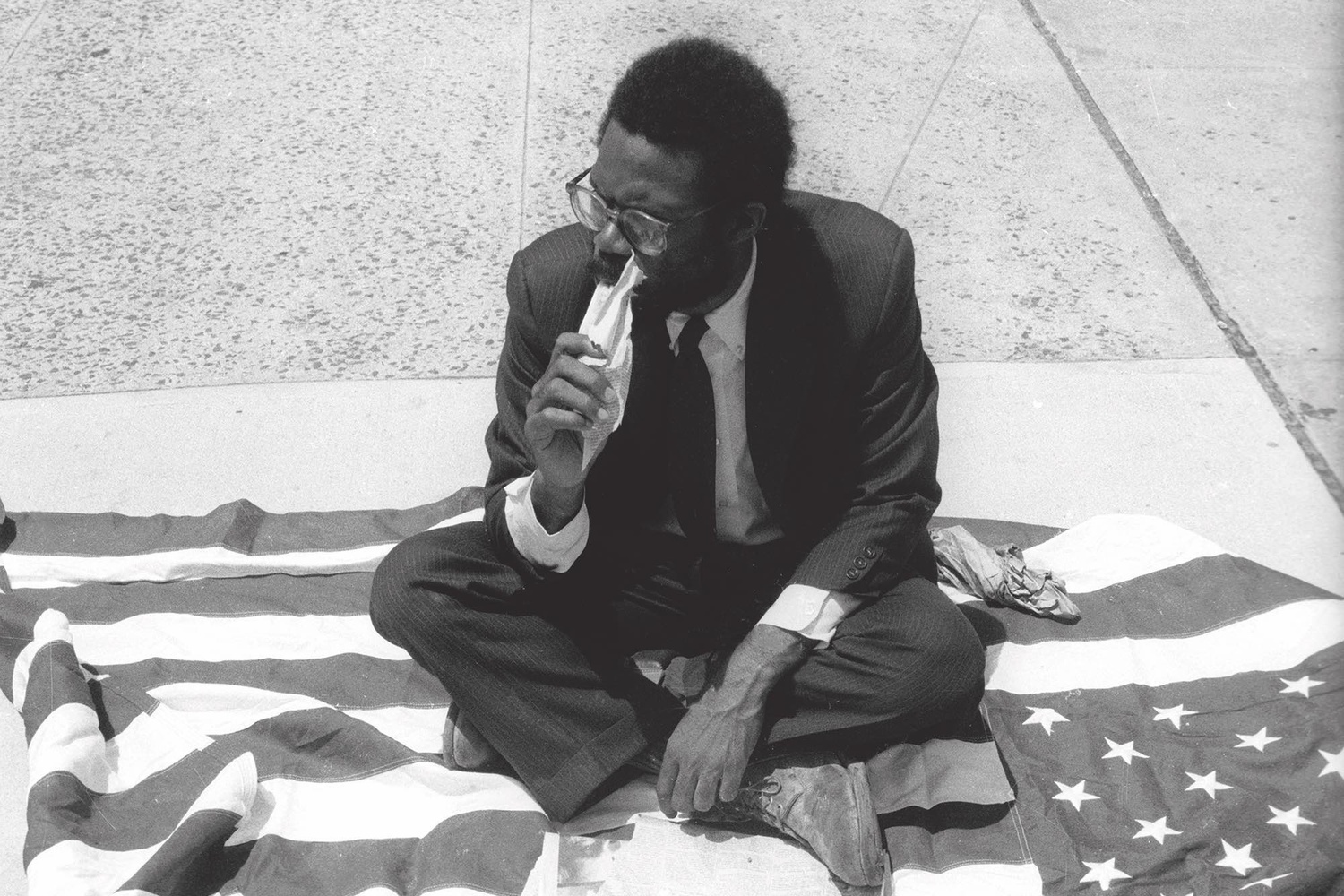 Pope.L, Eating the Wall Street Journal, early street version. 1991. © Pope.L. Courtesy the artist