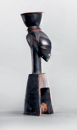 Attributed to the Master of Bouaflé, Guro peoples, Côte d’Ivoire. Heddle pulley. 19th century. Wood and pigment. 8 1/4 × 2 3/8 × 1 15/16 in. (21 × 6 × 5 cm). Fondation Musée Barbier-Mueller, Geneva. © Fondation Musée Barbier-Mueller, photo studio Ferrazzini-Bouchet