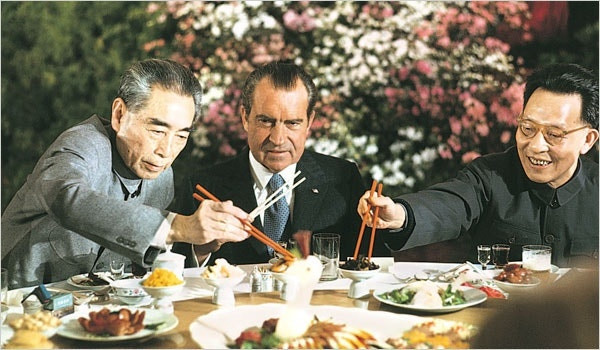 President Nixon holds his chopsticks in the ready position as Premier Chou En-lai (left) and Shanghai Communist Party leader Chang Chun-chiao reach in front of him for some tidbits at the beginning of the farewell banquet here. February 27, 1972