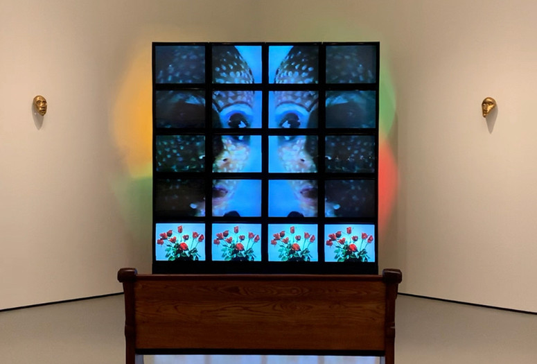 Theo Eshetu. Till Death Do Us Part. 1982–87. Two-channel video (color, sound; duration variable), 20 monitors, two clay masks, disco lights, and pew. Courtesy the artist. © 2020 Theo Eshetu. Digital image © 2020 The Museum of Modern Art, New York. Photo: Stuart Comer