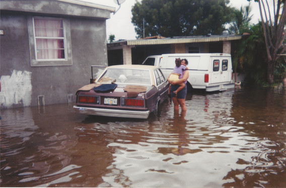 Photo of the author and her mother outside their former home in Miami, Florida. Their neighborhood would flood regularly after storms and heavy rains. c. 2001