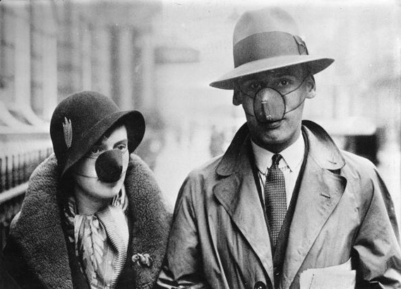A couple wearing masks with disinfecting cotton wool in order to protect themself against a flu infection, England, October 14, 1932