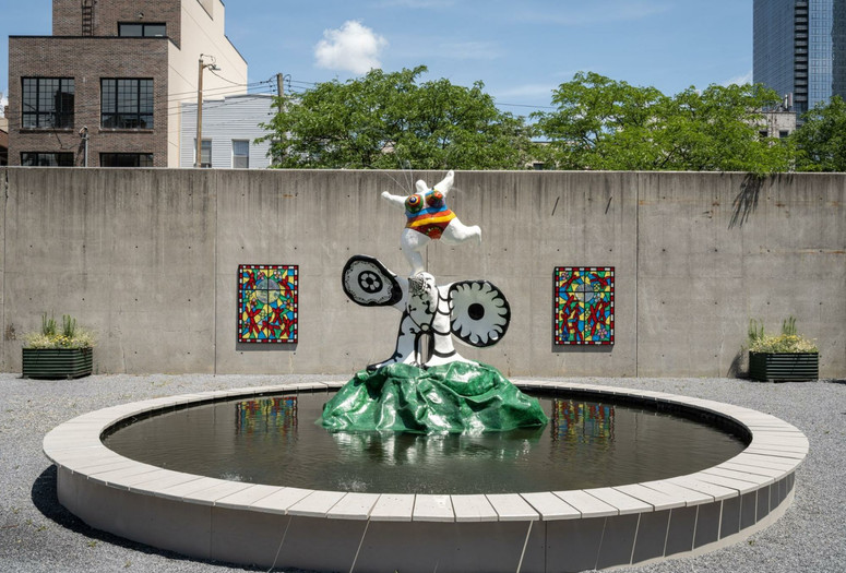View of the PS1 Courtyard. Shown: Niki de Saint Phalle. La femme et L'oiseau fontaine. 1967. Painted polyester resin. Courtesy Galerie Mitterrand, Paris; Galerie GP & N Vallois, Paris; and Salon 94, New York; Raúl de Nieves. The Stories of the Past Rejoice through Children's Skies. 2021. Courtesy the artist and Company Gallery, New York. Photo: Kris Graves