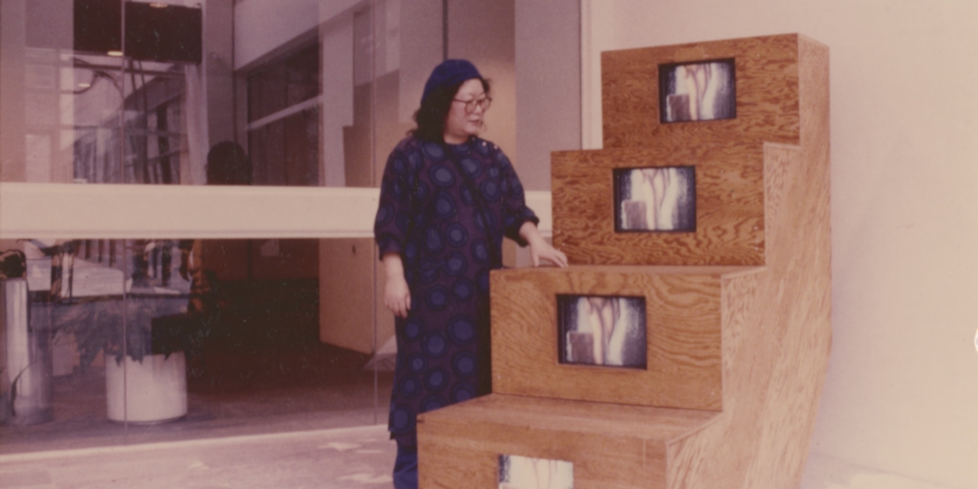 Shigeko Kubota with Duchampiana: Nude Descending a Staircase (1976) during the installation of Projects: Shigeko Kubota, The Museum of Modern Art, New York, 1976. Image courtesy Shigeko Kubota Video Art Foundation. © 2021 Estate of Shigeko Kubota/Licensed by VAGA at Artists Rights Society (ARS), New York