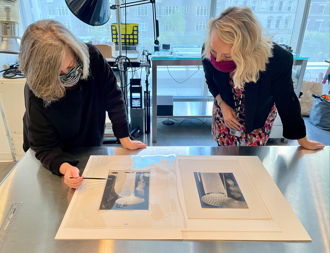Lee Ann Daffner and Jane Pierce comparing a plate from Champs Délicieux to an original Rayograph